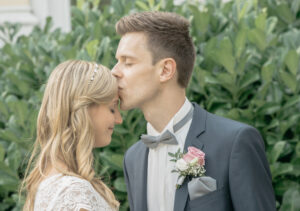 Hochzeitsfotografie Ehemann küsst Ehefrau auf der Stirn