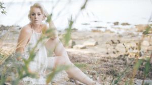 Sichliche Boudoirfotografie einer blonden Frau am Wasser