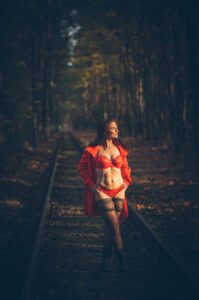 Erotik Boudoir Shooting einer Frau mit roter Reizwäsche auf Zuggleisen